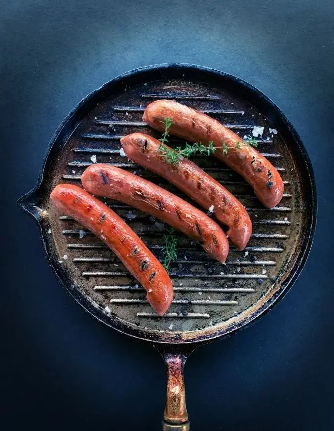 Saucisses dans une poele, aliment riche en histamine